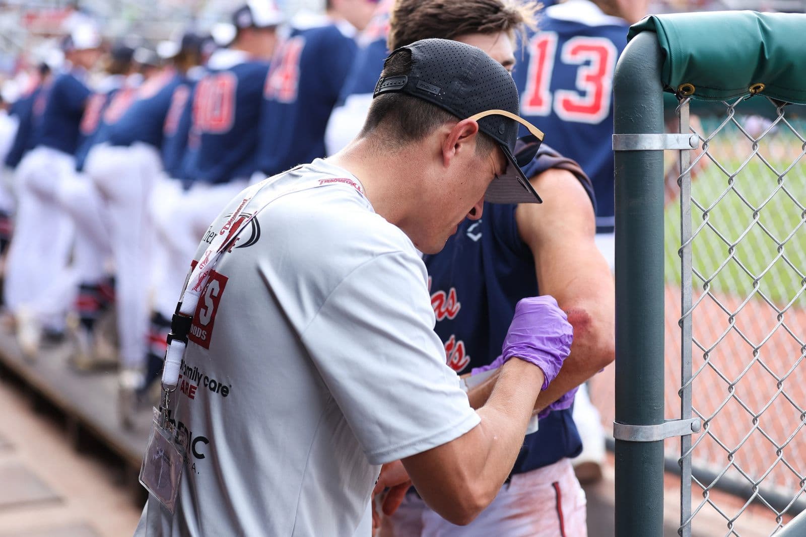 Eric Archuleta taping a baseball player's elbow in the dugout